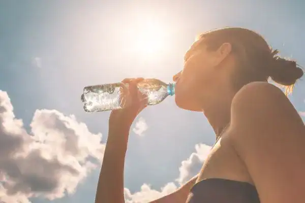 Hydration: The Secret Ingredient for a Toned Stomach and Enhanced Fitness 3 Image of woman drinking water to hydrate Kent after run.